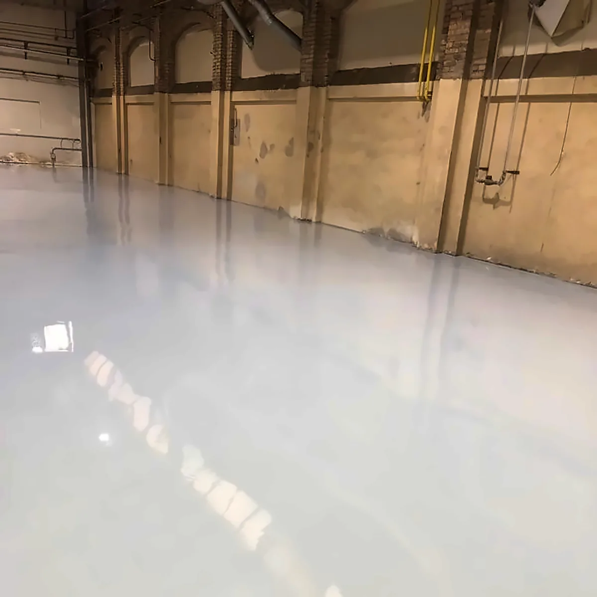 Glossy light-grey epoxy floor running the length of the industrial hall, Palma Glossy light-grey epoxy floor running the length of the industrial hall, Palma