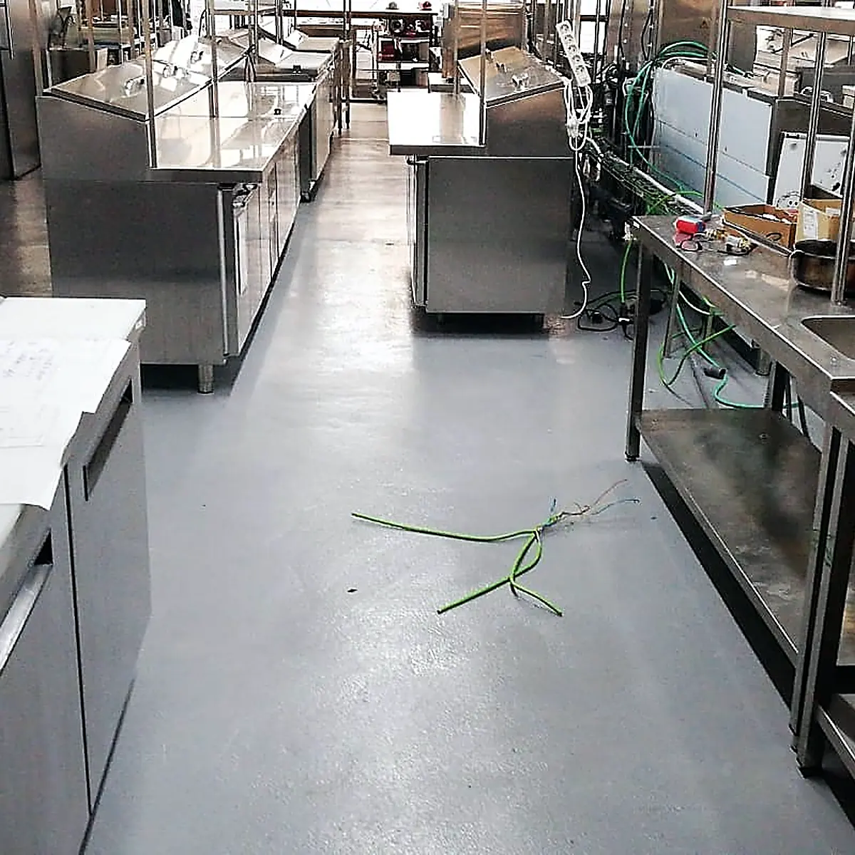 Cold counters and worktops on the finished grey floor of the professional kitchen