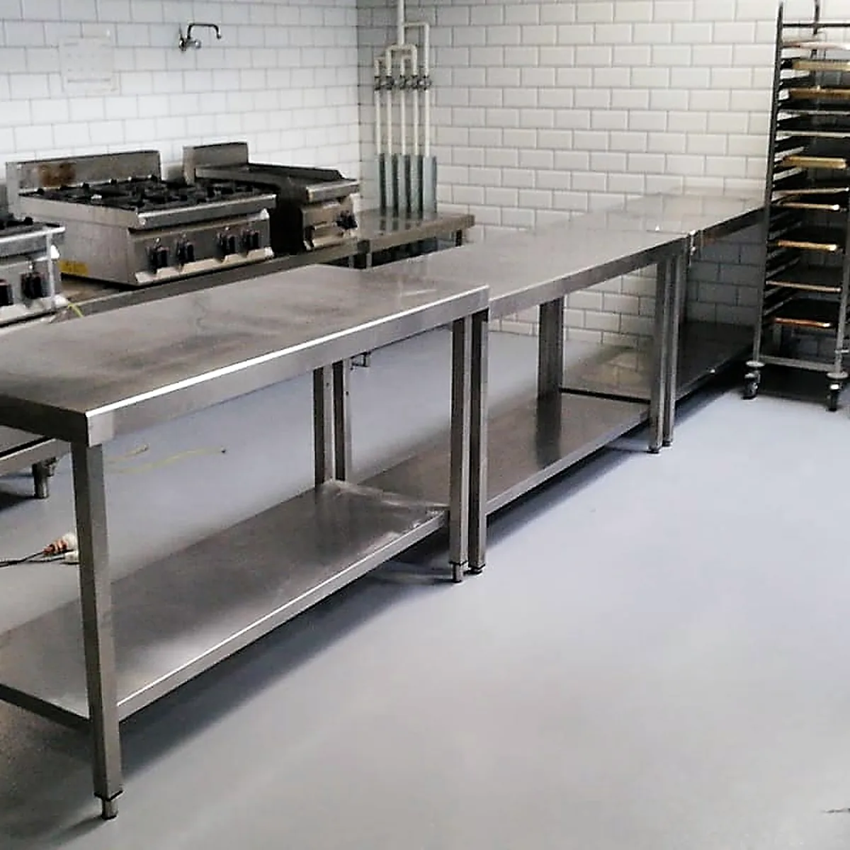 Cooking range and steel table on the grey multilayer epoxy floor, Barcelona
