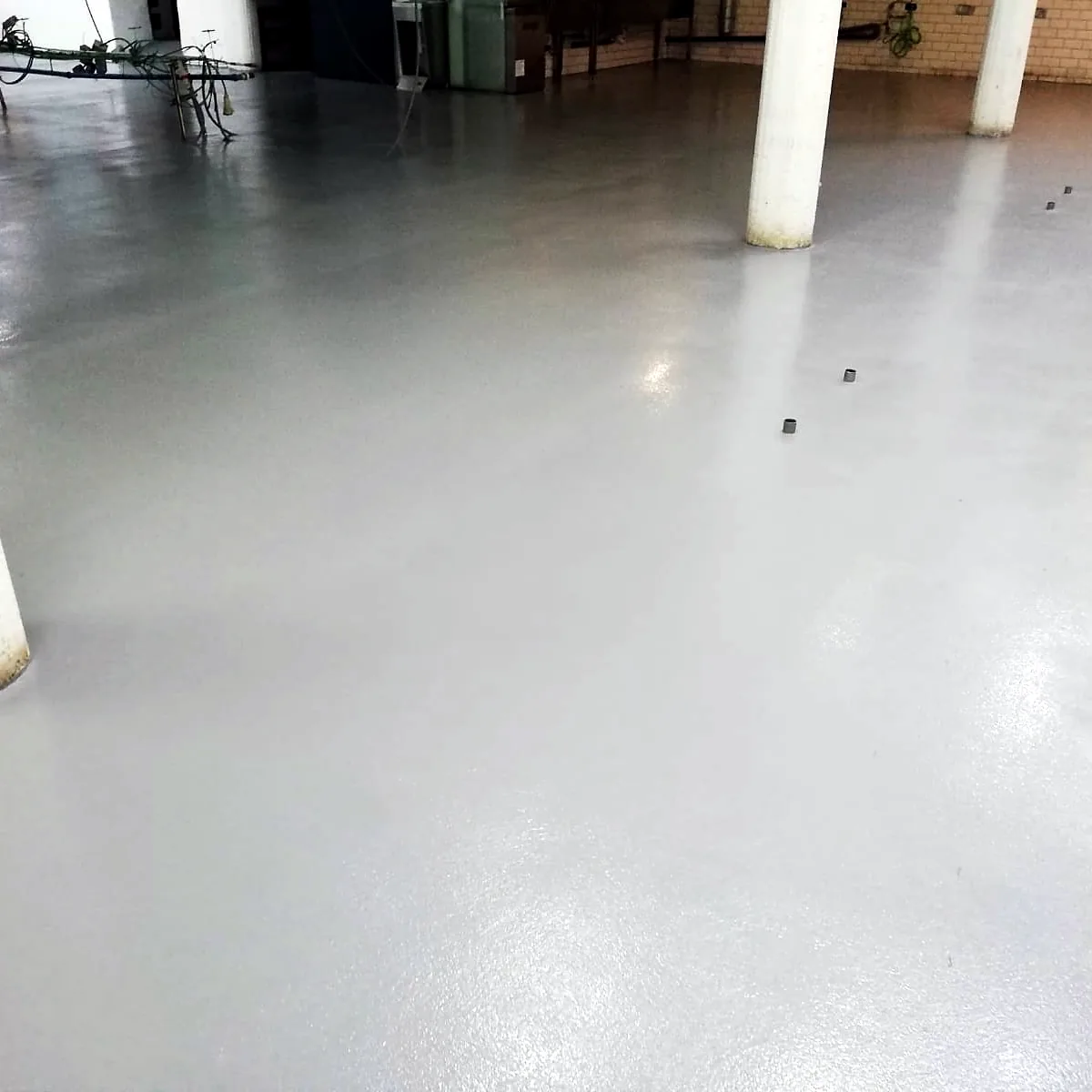 Glossy grey epoxy floor between the columns of the Barcelona kitchen