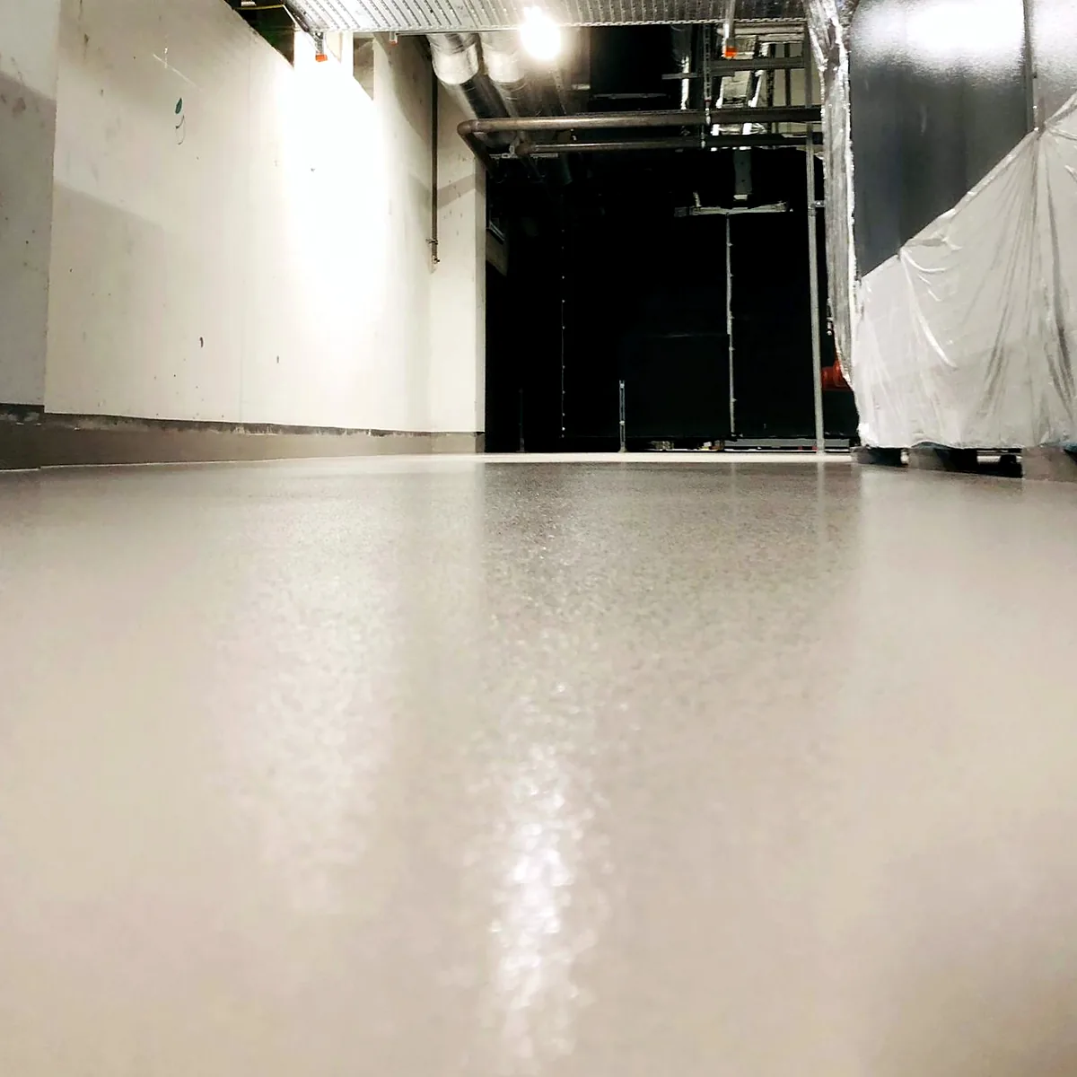 Open floor area with a glossy grey polyurethane finish in an industrial kitchen