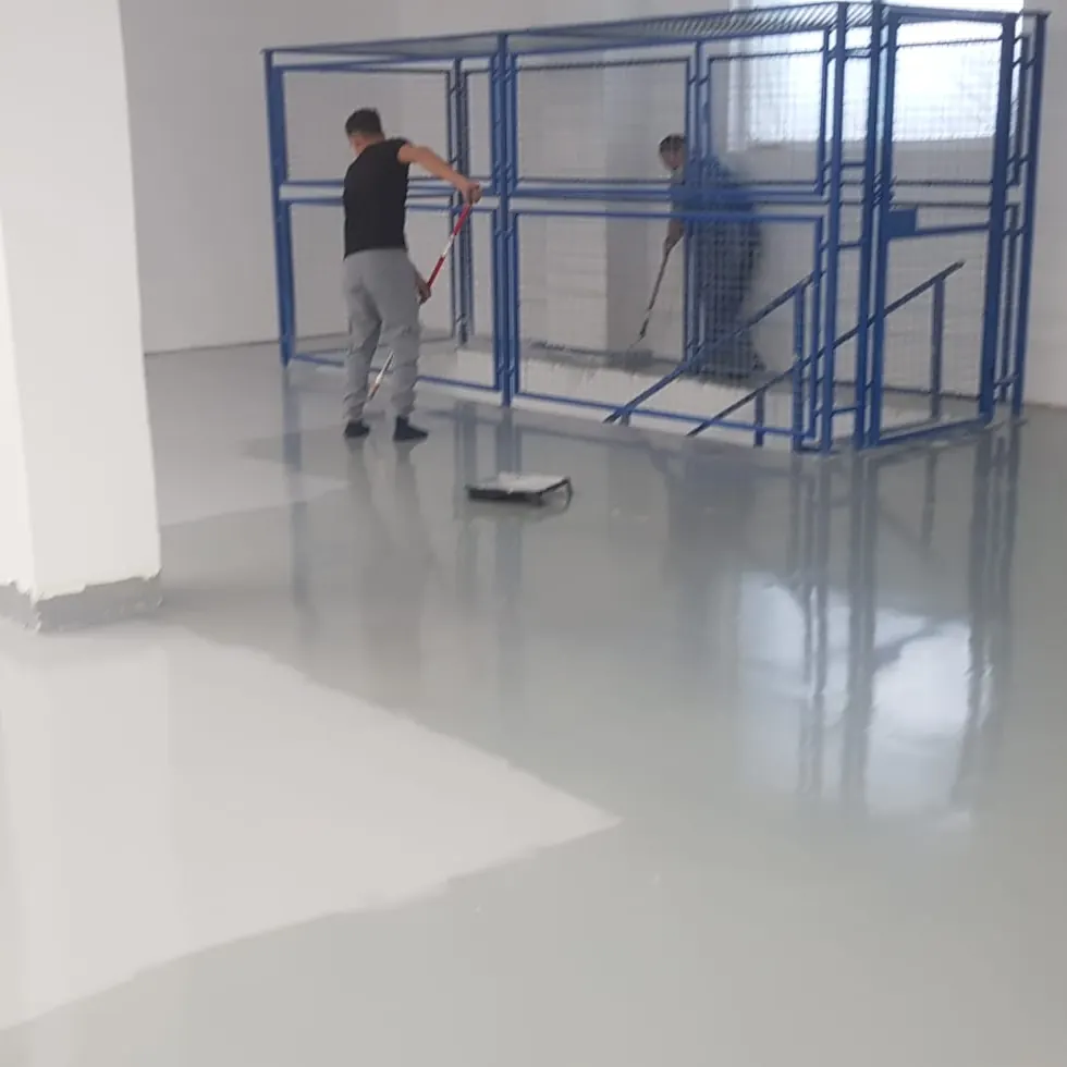 Dos operarios con herramientas junto a una jaula azul Dos operarios con herramientas junto a una jaula azul