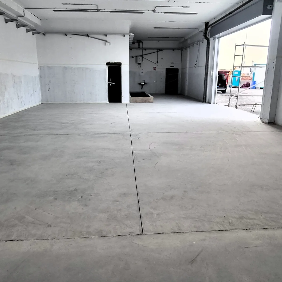 Bare concrete floor in the empty hall before coating