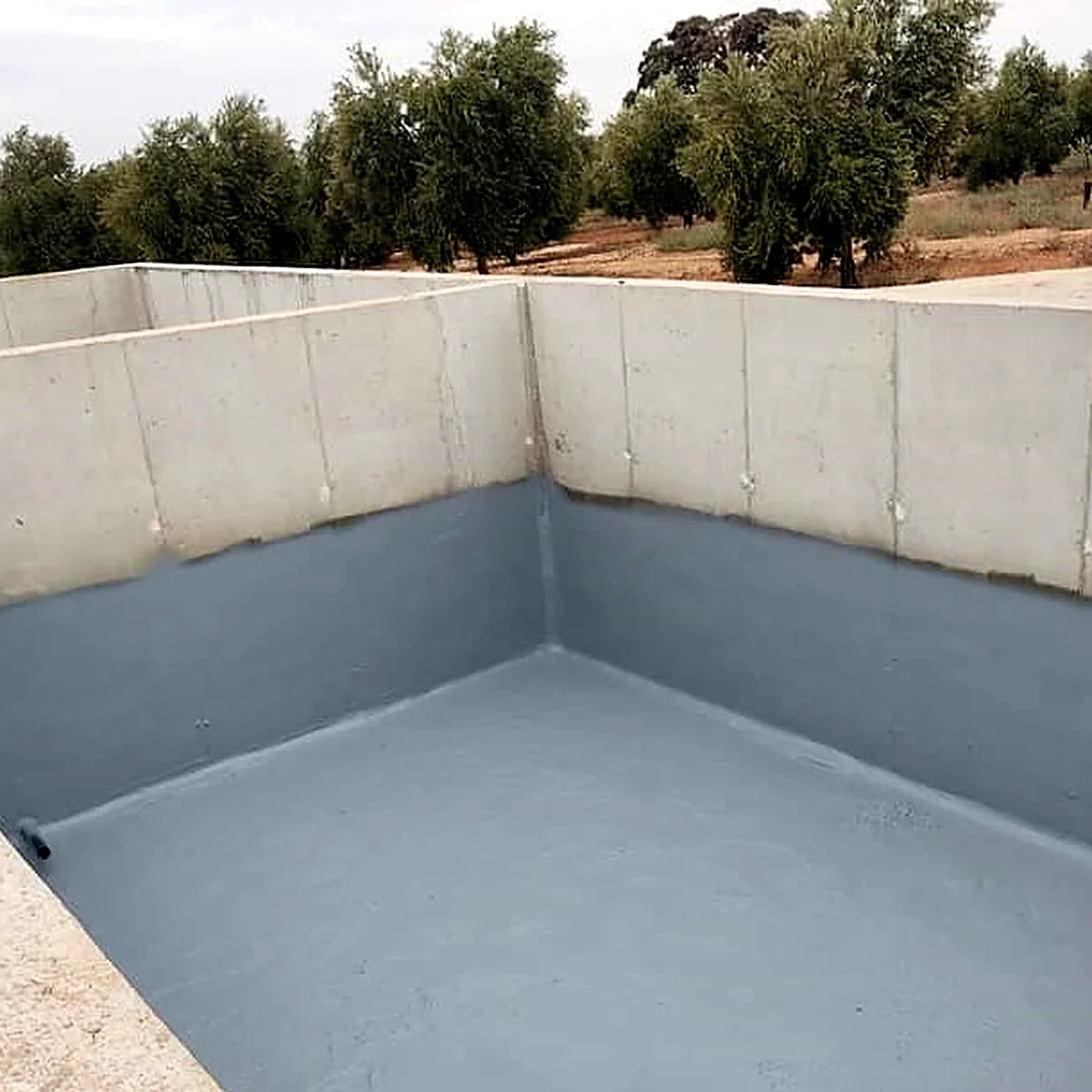 Irrigation reservoir waterproofing in Andalusia: grey Polyurea Rayston lining on the walls and floor of a concrete reservoir Irrigation reservoir waterproofing in Andalusia: grey Polyurea Rayston lining on the walls and floor of a concrete reservoir
