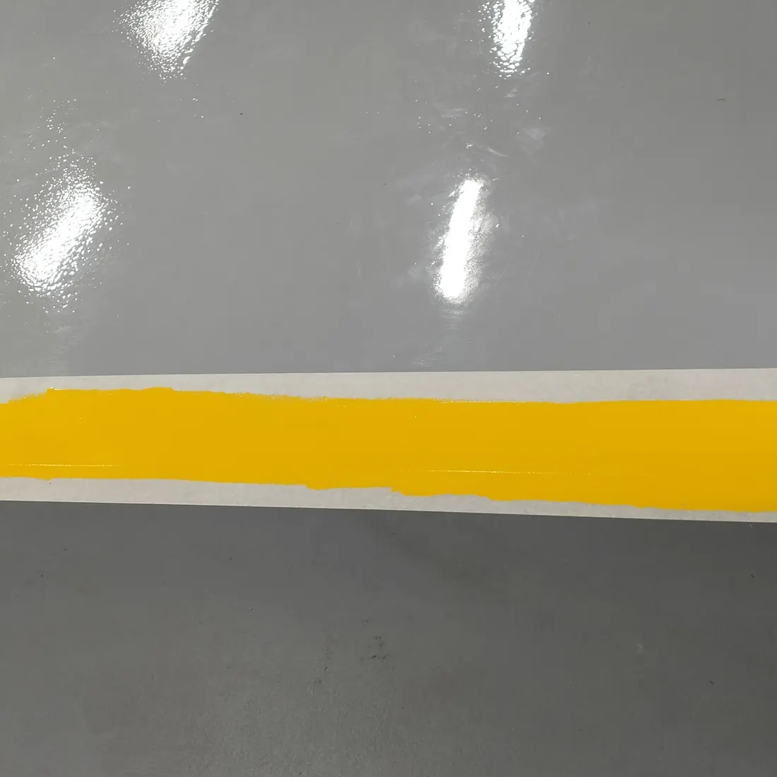 A yellow band across the grey floor A yellow band across the grey floor