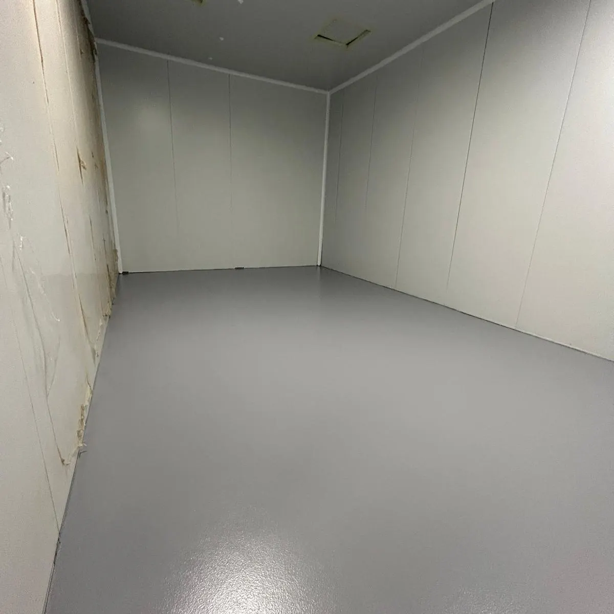 Pavimento gris terminado reflejando los paneles LED del techo, HIPRA Girona