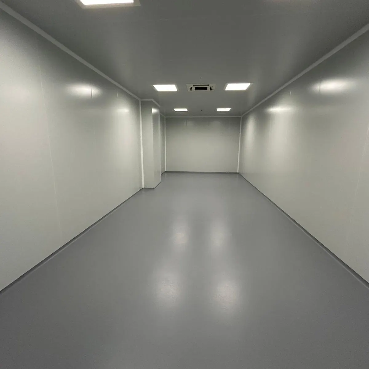 Sala blanca diáfana con pavimento epoxi gris continuo, Aiguaviva