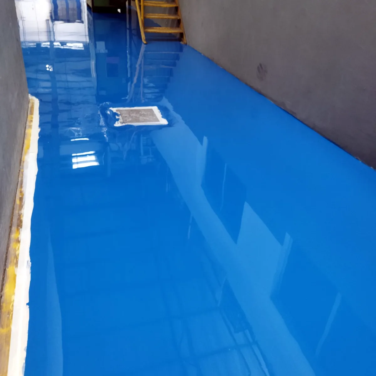 Bright blue floor at the foot of a yellow steel stair, Porto