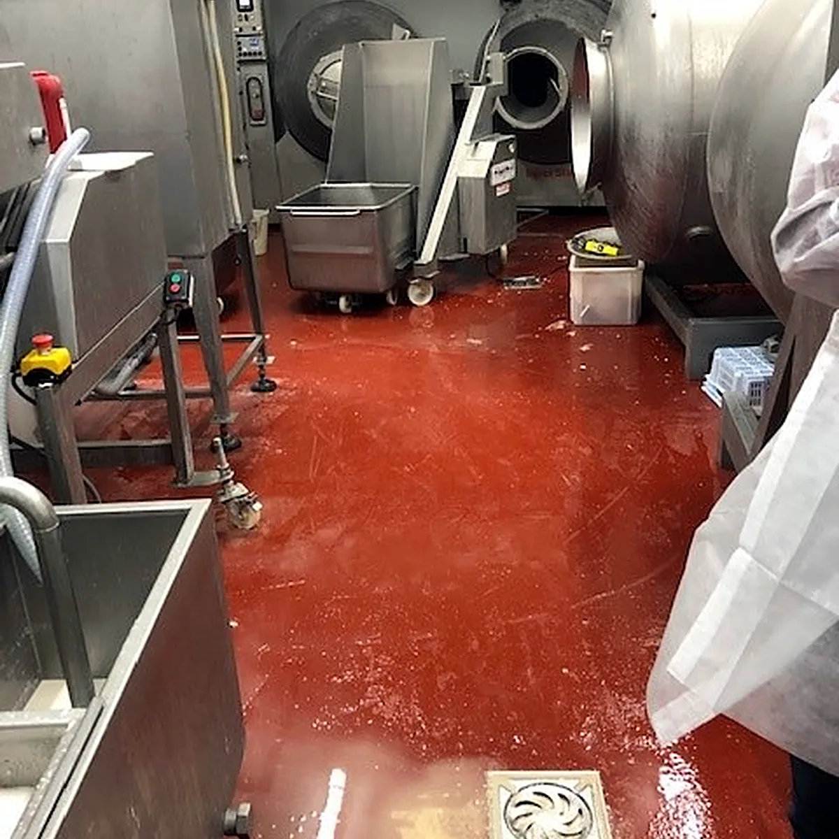 Floor drain set in the glossy red epoxy floor of the machine room Floor drain set in the glossy red epoxy floor of the machine room