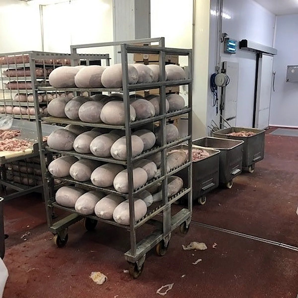 Racks of hams on the red epoxy floor in the meat workshop, Sant Pere de Riudebitlles Racks of hams on the red epoxy floor in the meat workshop, Sant Pere de Riudebitlles