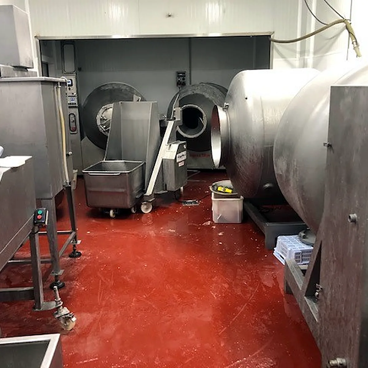 Meat tumblers and trolleys on the red epoxy floor, Barcelona province Meat tumblers and trolleys on the red epoxy floor, Barcelona province