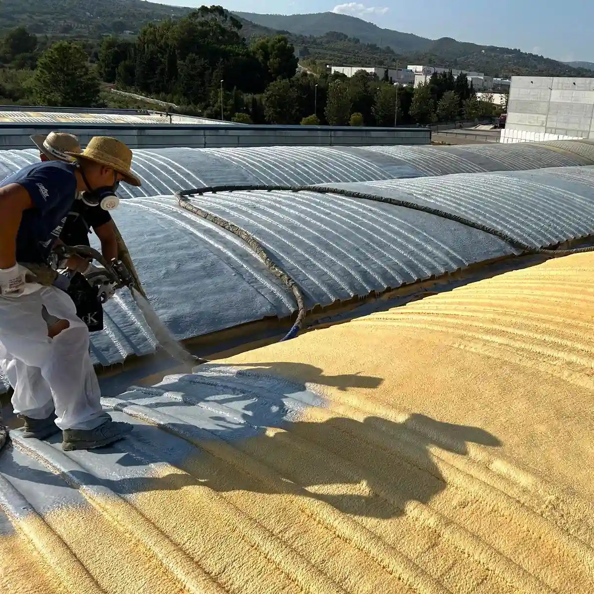 Spray gun applying grey polyurea on foam, La Selva del Camp