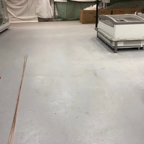 The floor turning past a freezer and a ladder