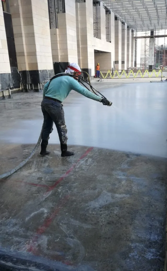 A spray pass from the edge of the bay, the wet film locking over the concrete.