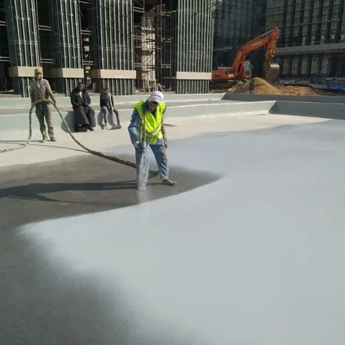 Hot-spray polyurea on the podium deck, with the ministry towers still in scaffold.