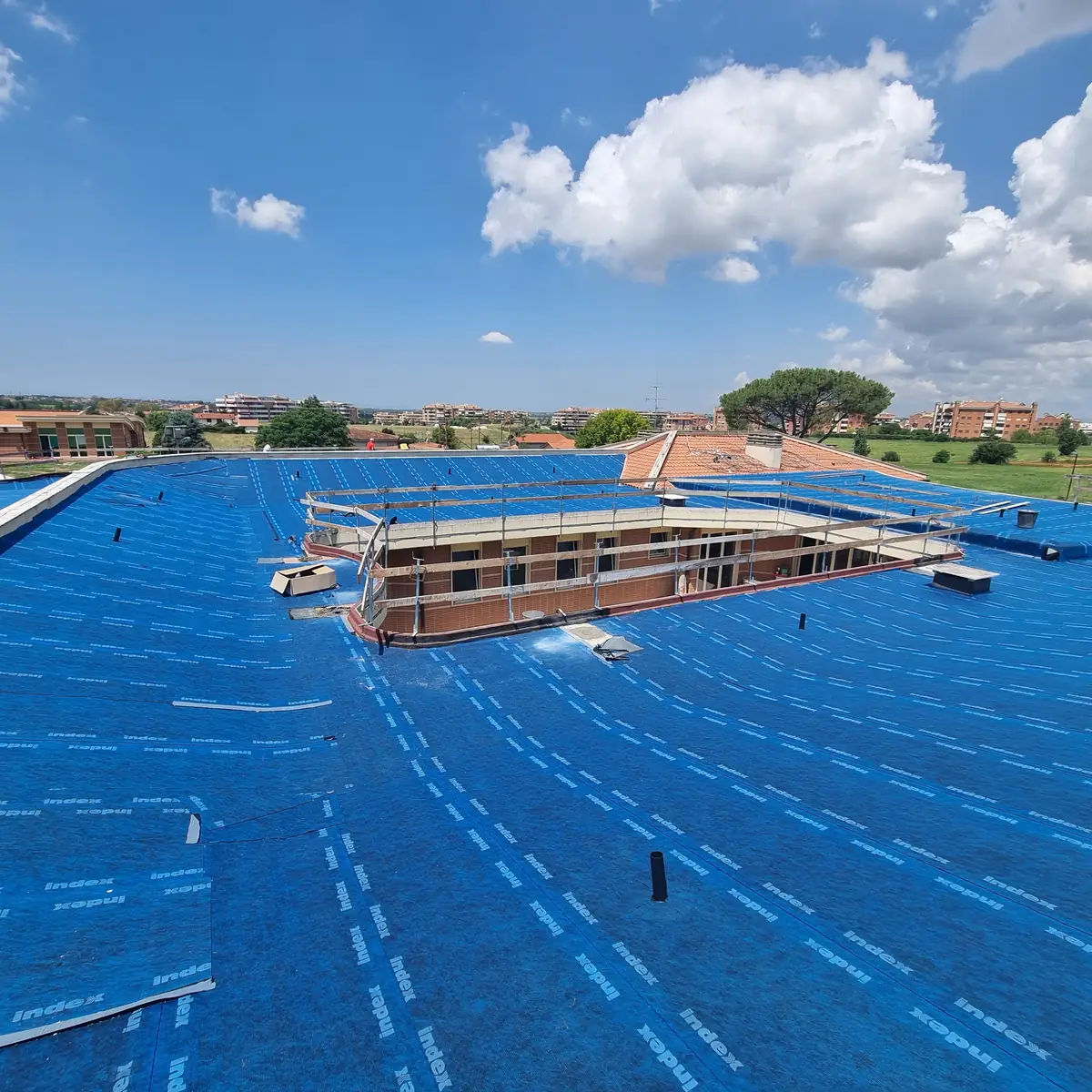 Self-adhesive bituminous sheet being laid on the nursery roof
