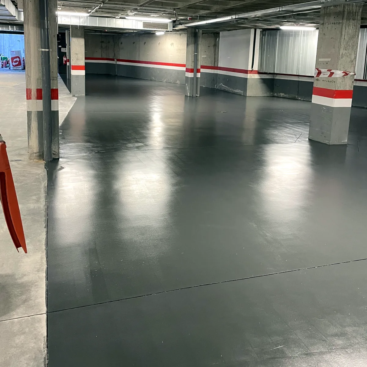 Glossy dark grey aisle running between pillars, Madrid office car park Glossy dark grey aisle running between pillars, Madrid office car park