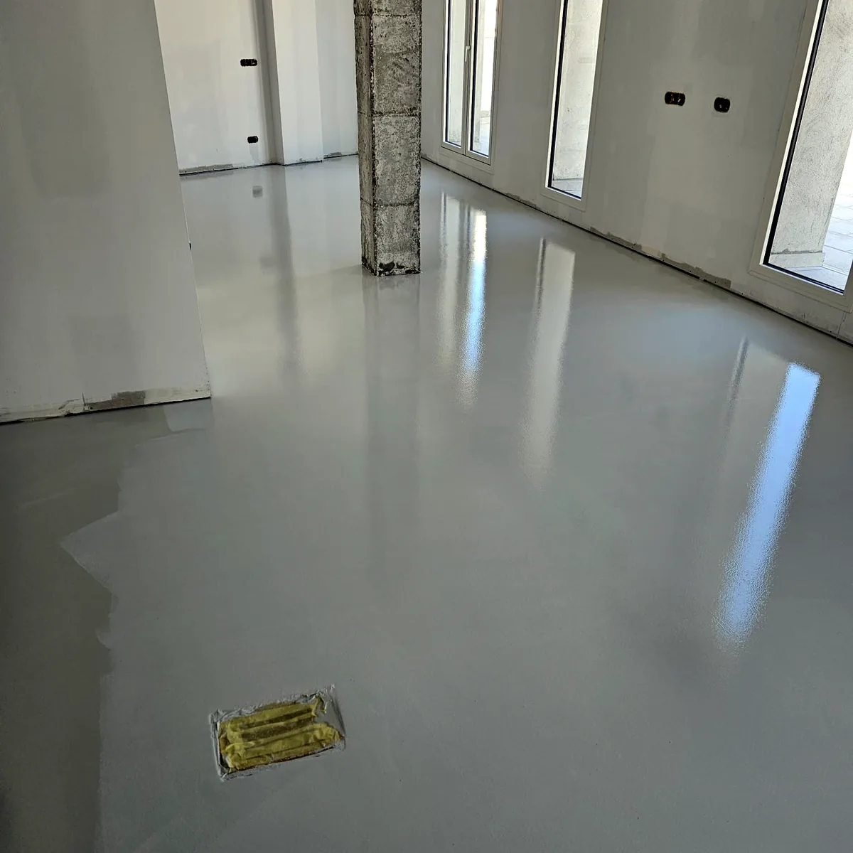 Glossy pale grey floor across an open-plan office with tall windows, Barcelona