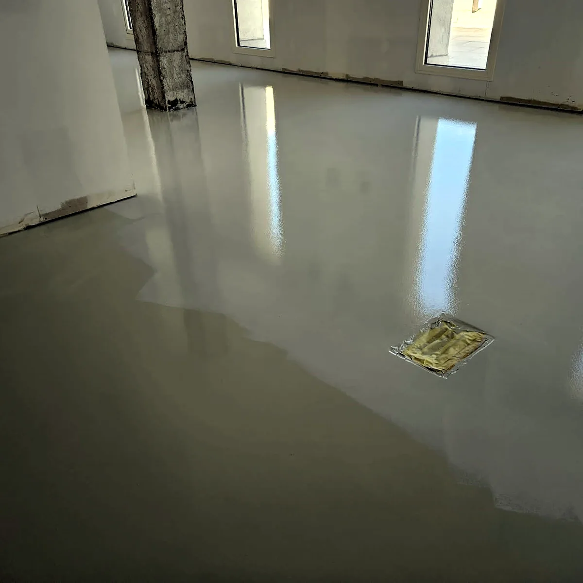 Pale floor reflecting a row of windows in an empty office space