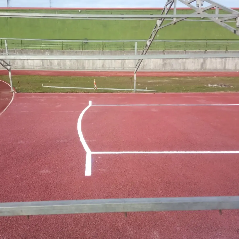 White lane lines on the red track, with the bend in the background