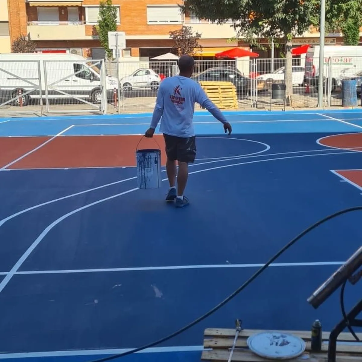 Court field being coated with apartment blocks behind, Granollers