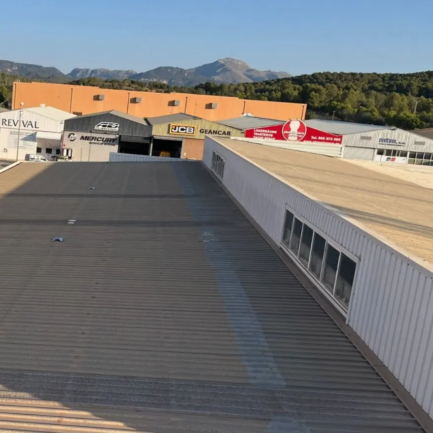 The coated roof running toward the hills