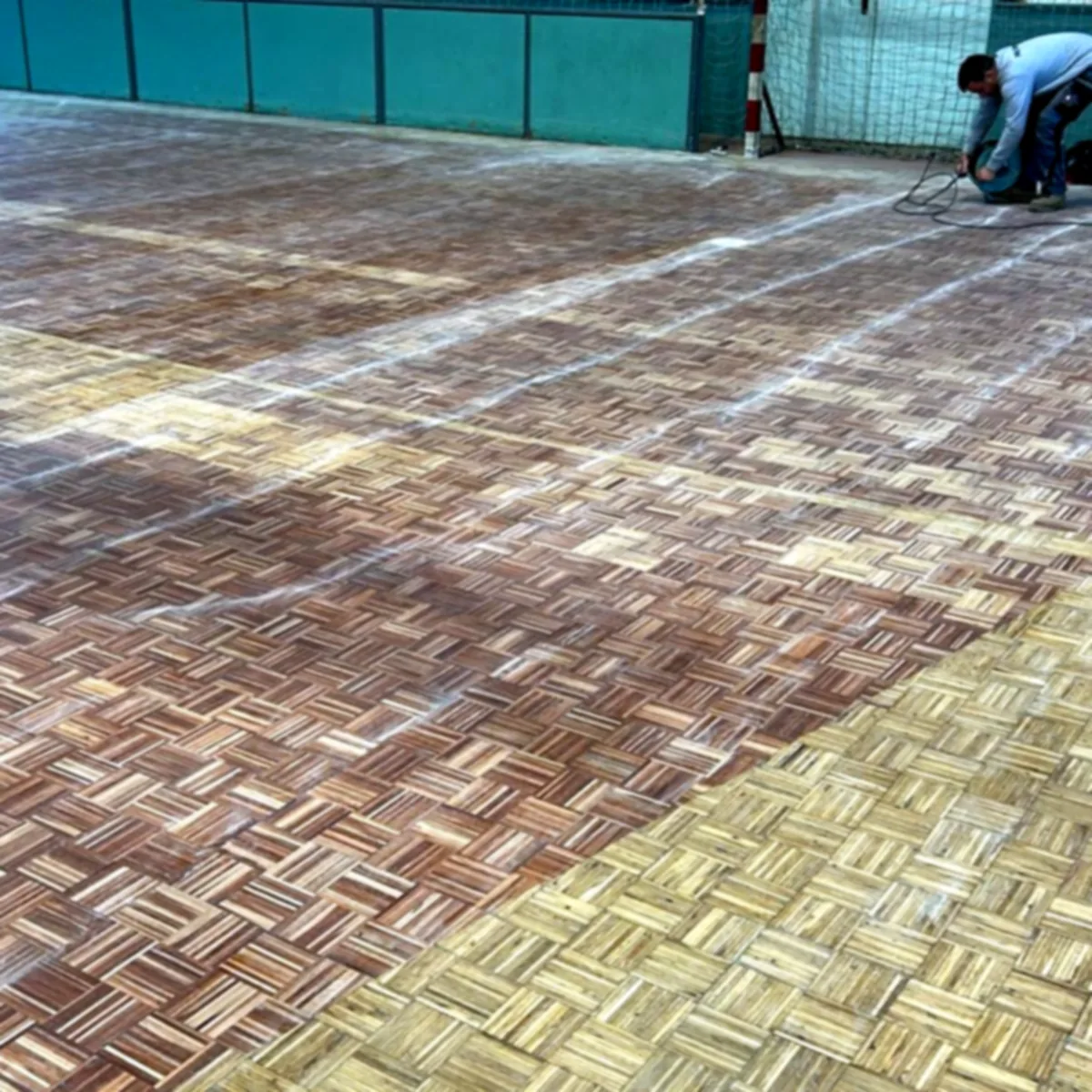 Crew sanding back the old parquet court surface in Granollers