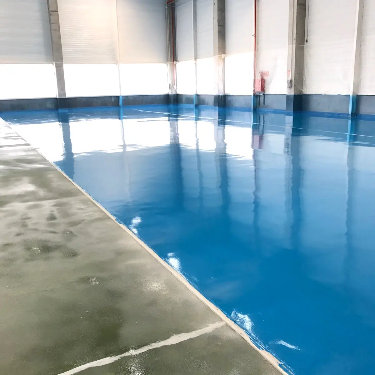 Glossy blue floor edge beside bare concrete, Algeria pharma plant