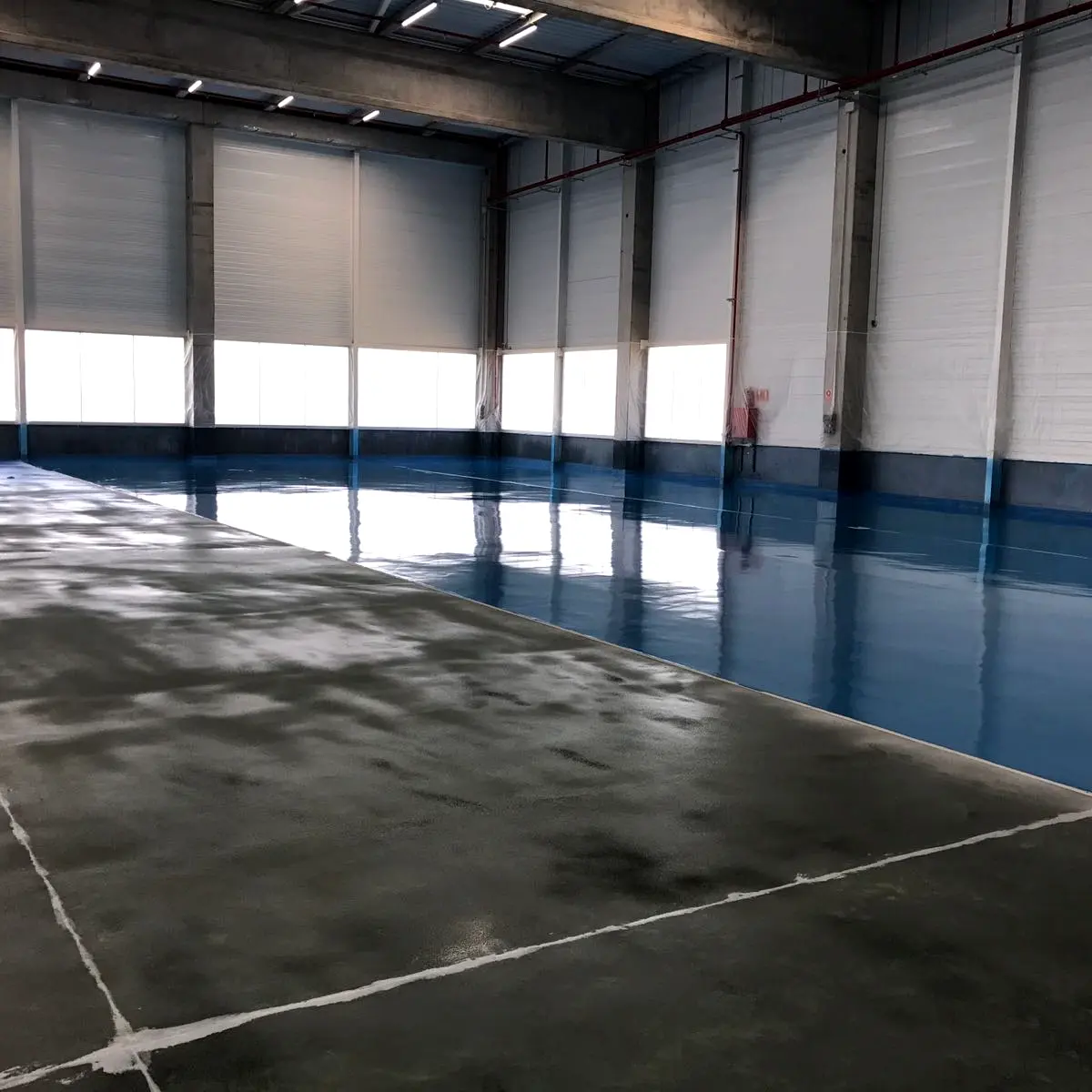Prepared concrete beside a finished blue bay, Algeria pharma plant