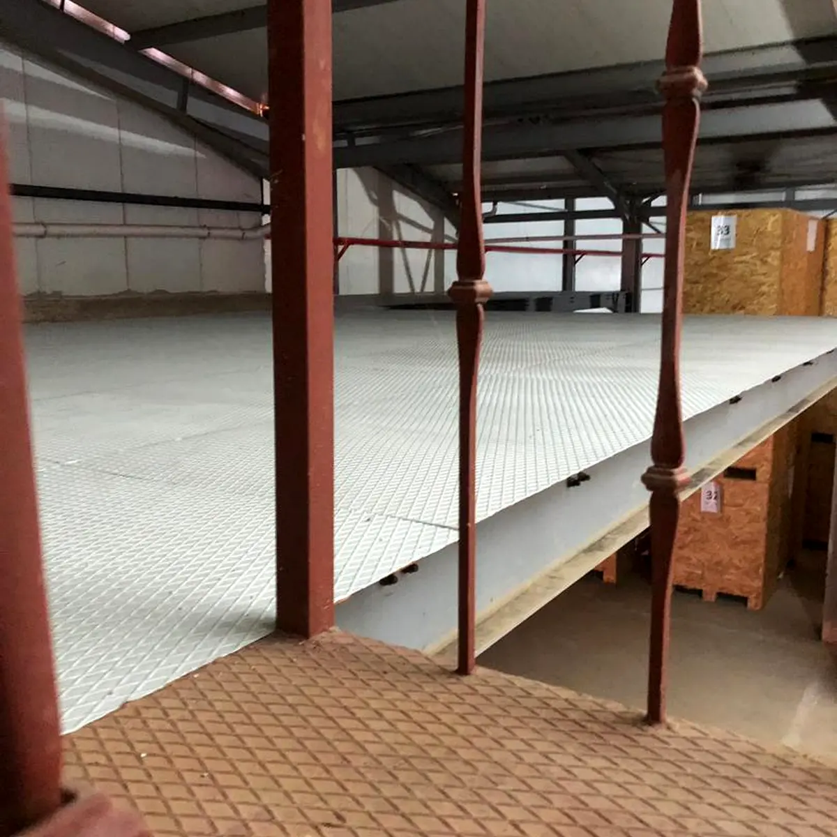 Grey textured mezzanine floor behind red railings, Algeria pharma plant