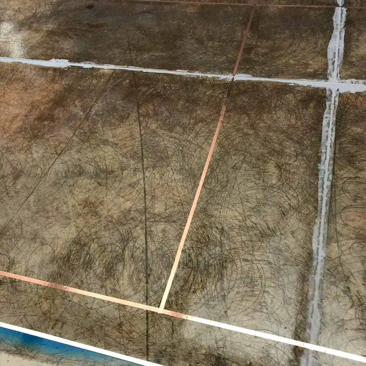 Close-up of copper tape crossing filled joints, Algeria pharma plant