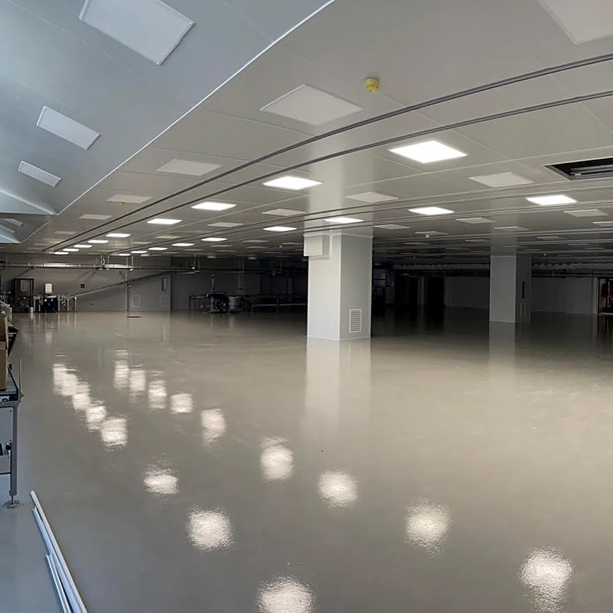 Open grey floor running to the far wall of the plant