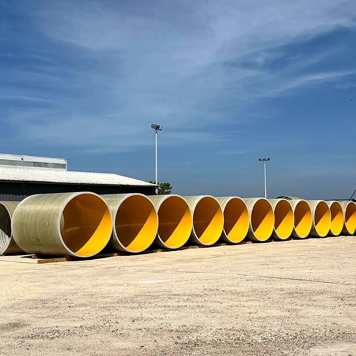 Pipe lining Colombia: stacked pipes with yellow polyurea lining in a storage yard Pipe lining Colombia: stacked pipes with yellow polyurea lining in a storage yard