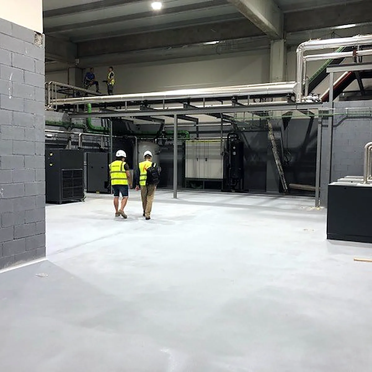 Light grey Impermax 2K M floor in a plant hall with machinery at the back, Sallent Light grey Impermax 2K M floor in a plant hall with machinery at the back, Sallent