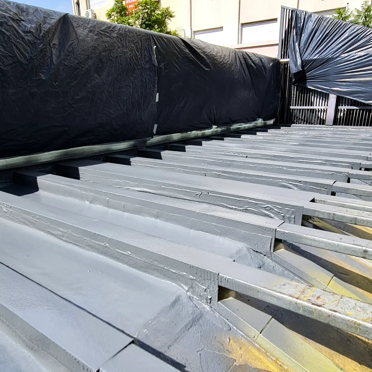 Prepared sloped roof with black sheeting along the edges before spraying, Buenos Aires