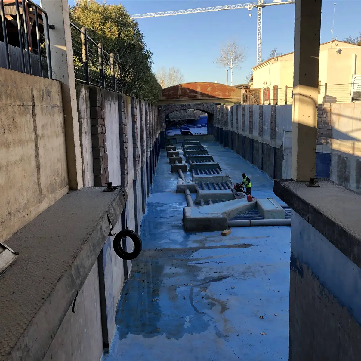 Long concrete channel with pipe manifolds during preparation, Parque Warner Madrid