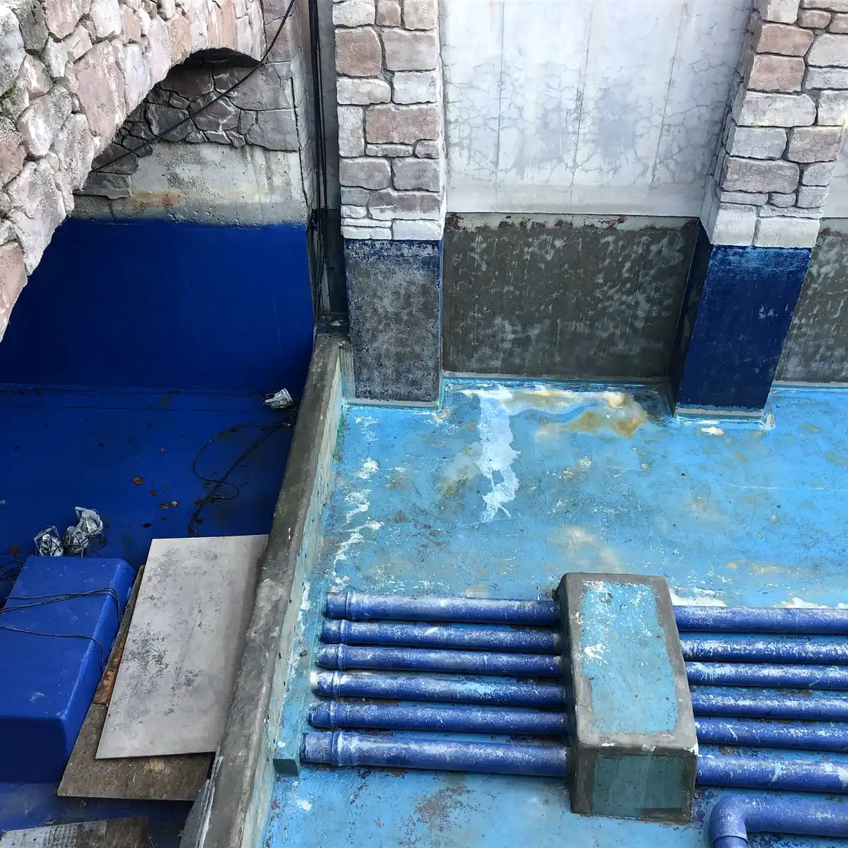 Blue lining at a wall base under a stone arch, Parque Warner Madrid