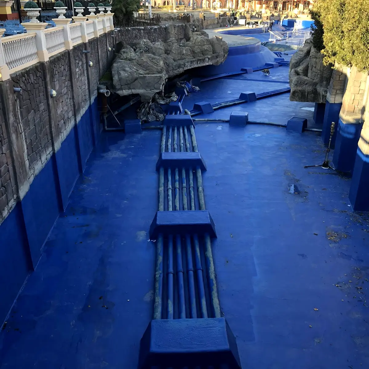 Blue-lined channel floor and lower walls beside rockwork, Parque Warner Madrid