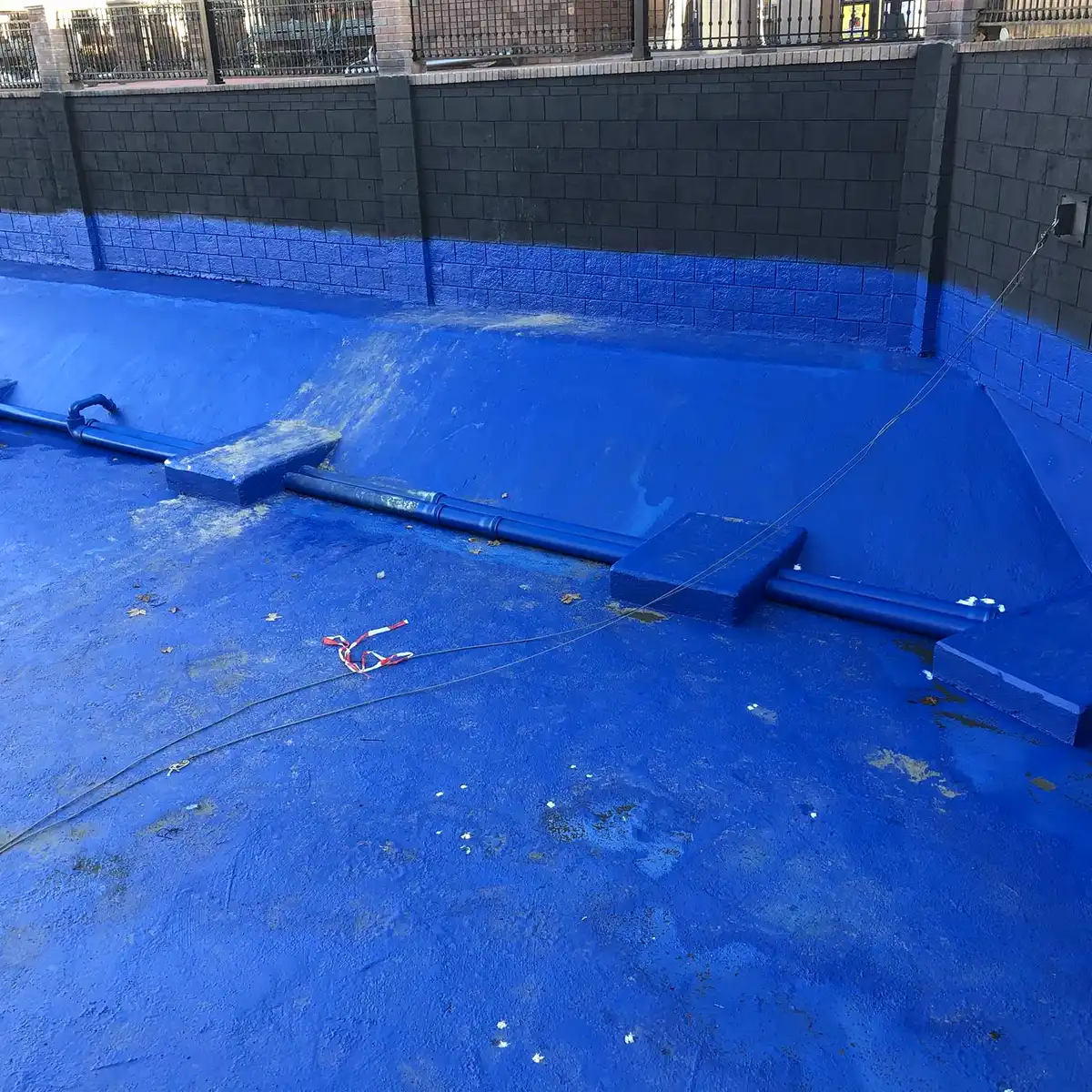 Blue polyurea lining turned up a basin wall, Parque Warner Madrid