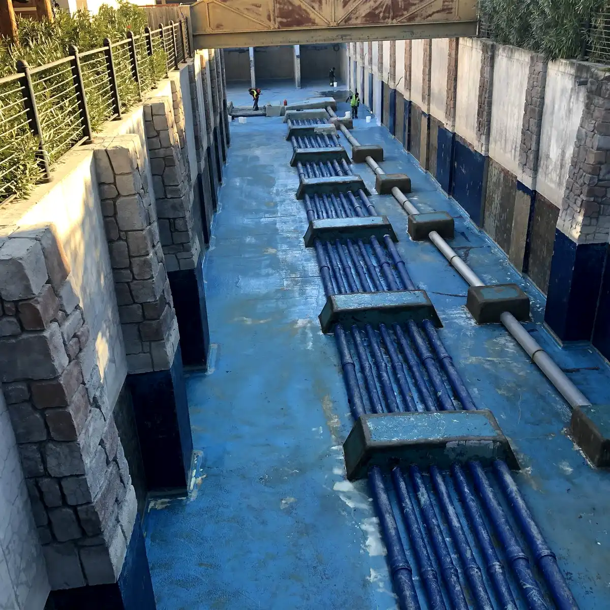 Channel with pipe manifolds between stone-clad walls, Parque Warner Madrid