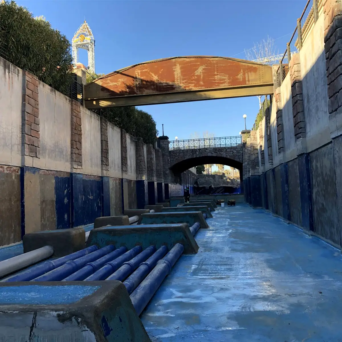 Channel under a footbridge with blue lower walls, Parque Warner Madrid