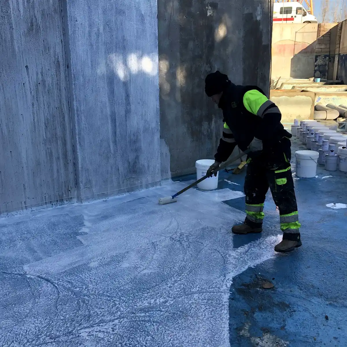 Worker rolling primer across a basin floor, Parque Warner Madrid
