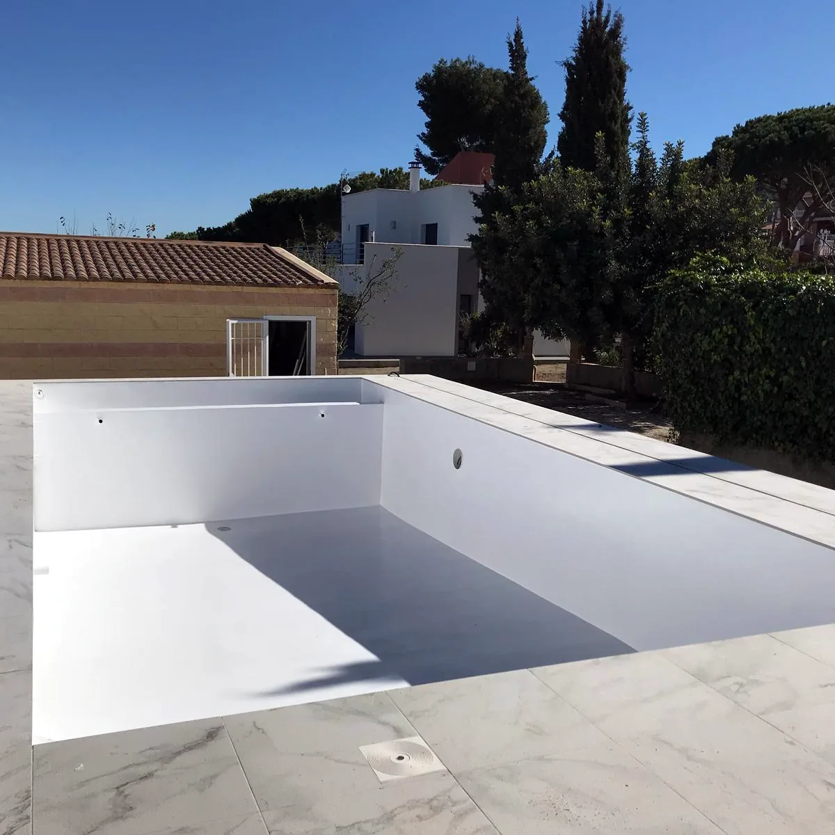 Empty pool with a white finish beside a marble-look terrace, Marbella Empty pool with a white finish beside a marble-look terrace, Marbella