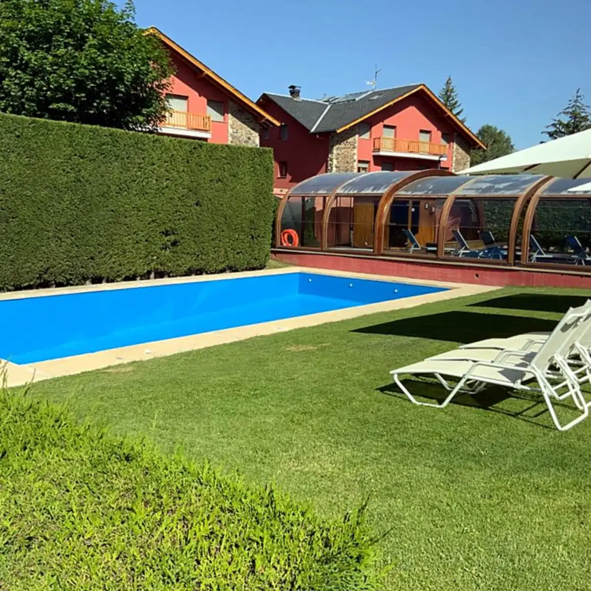 Blue pool beside a lawn with sun loungers and a parasol, Queixans Blue pool beside a lawn with sun loungers and a parasol, Queixans