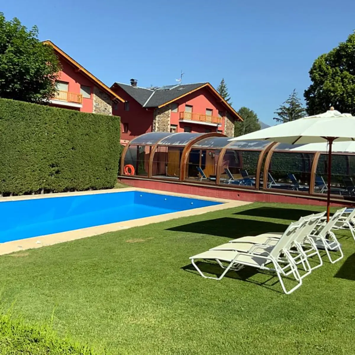 Pool seen from the garden with houses and trees behind Pool seen from the garden with houses and trees behind