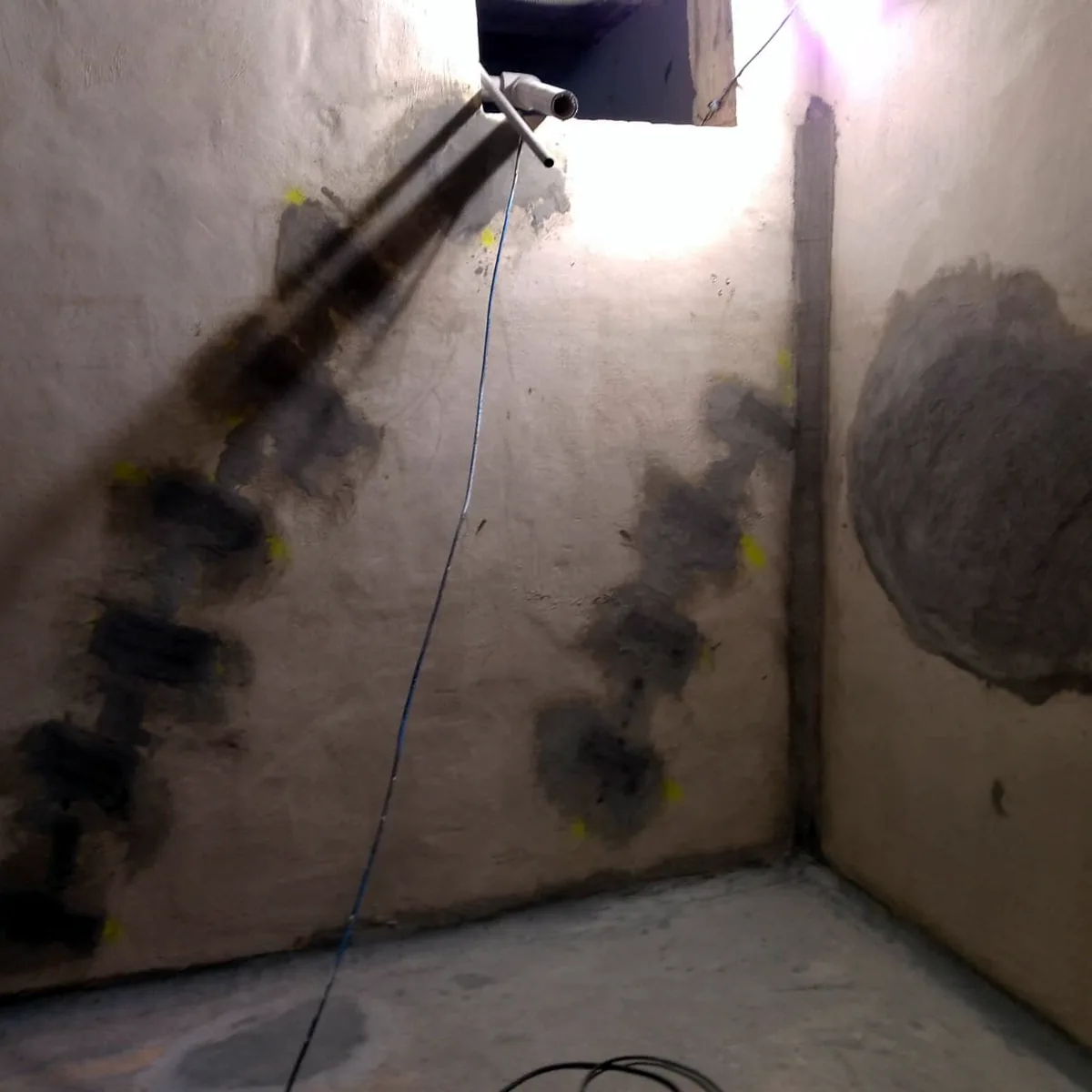 Dark repair patches along the wall cracks before the membrane