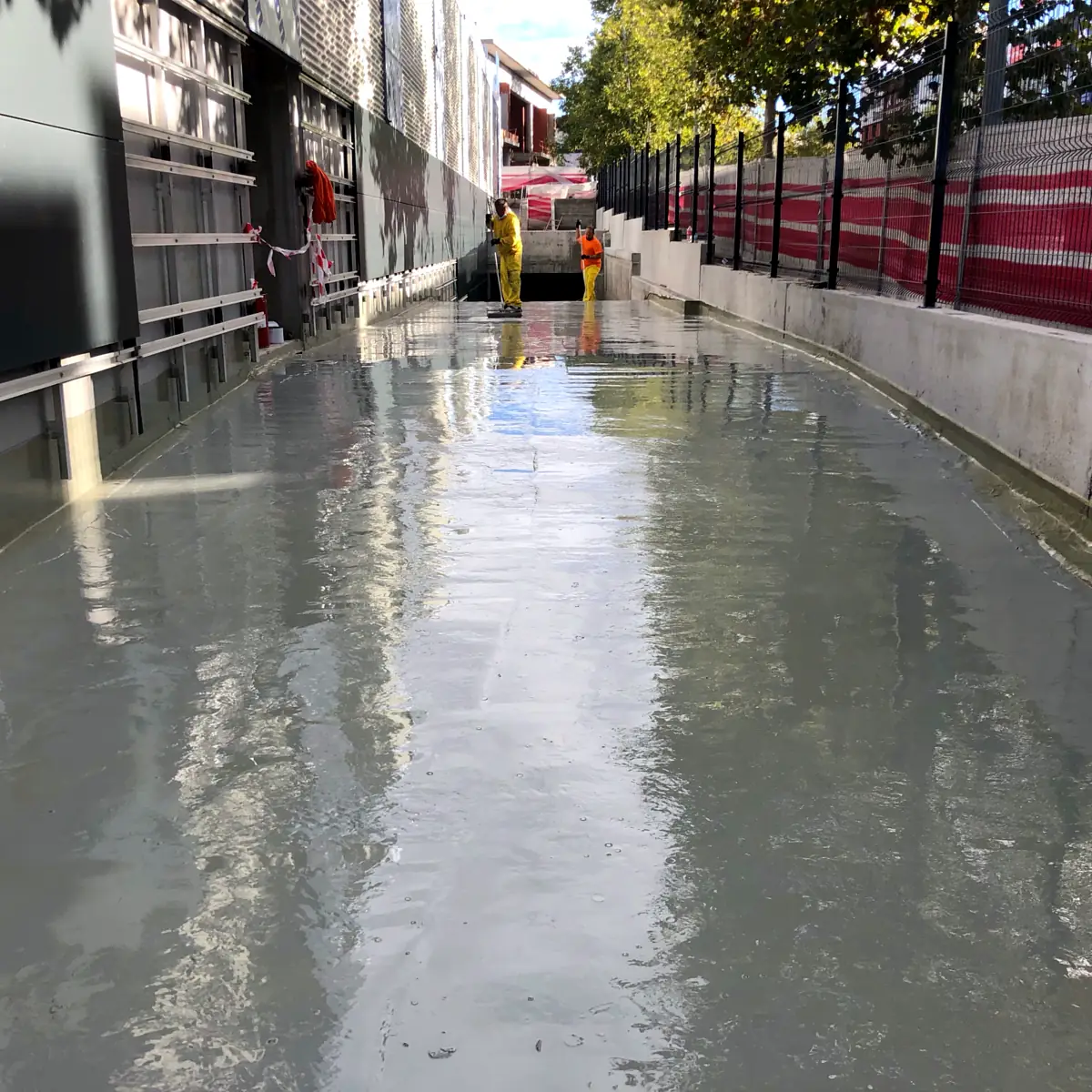 Carril de acceso junto a la fachada del supermercado tras la impermeabilización, Madrid
