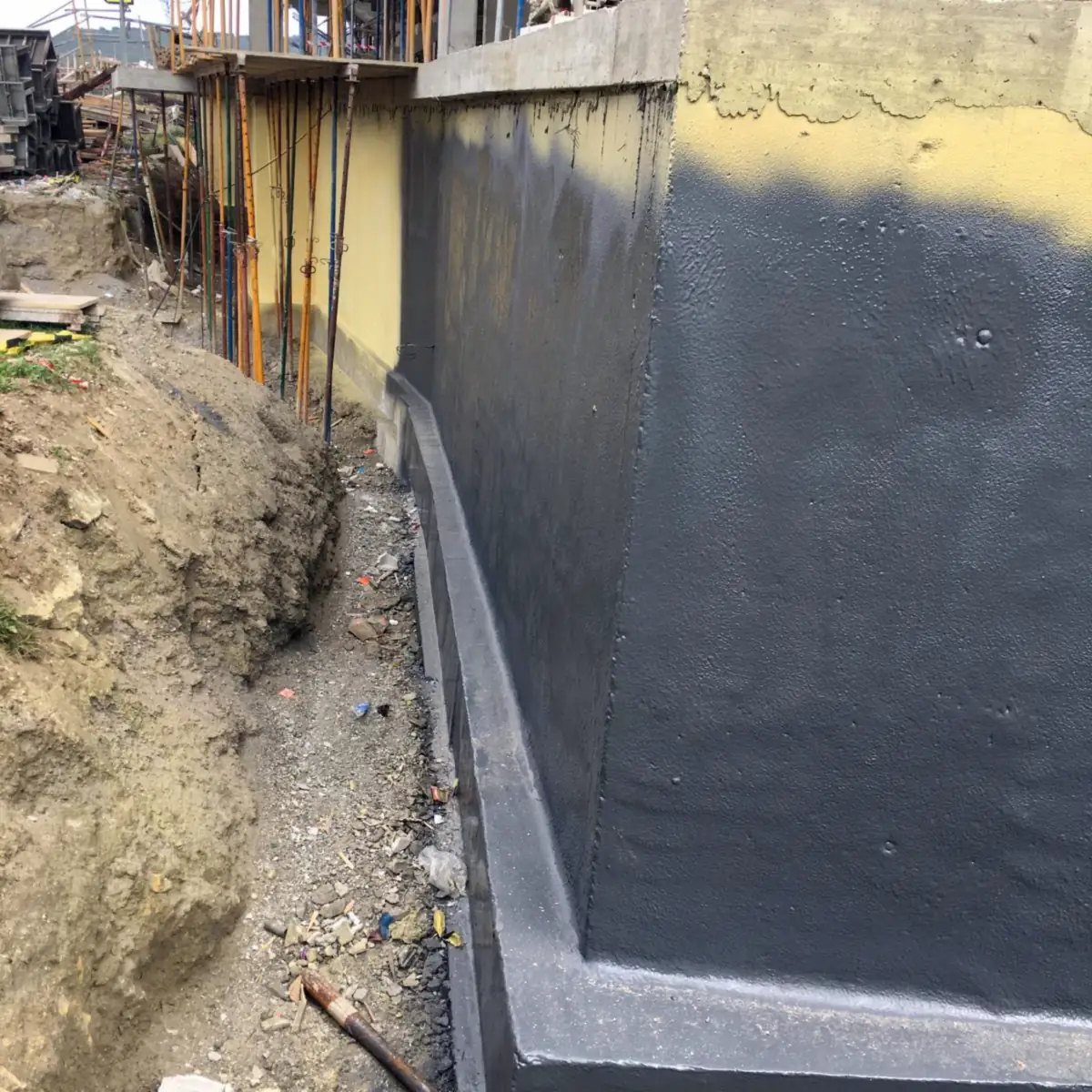 Grey radon barrier membrane down a foundation wall into the trench, residential building