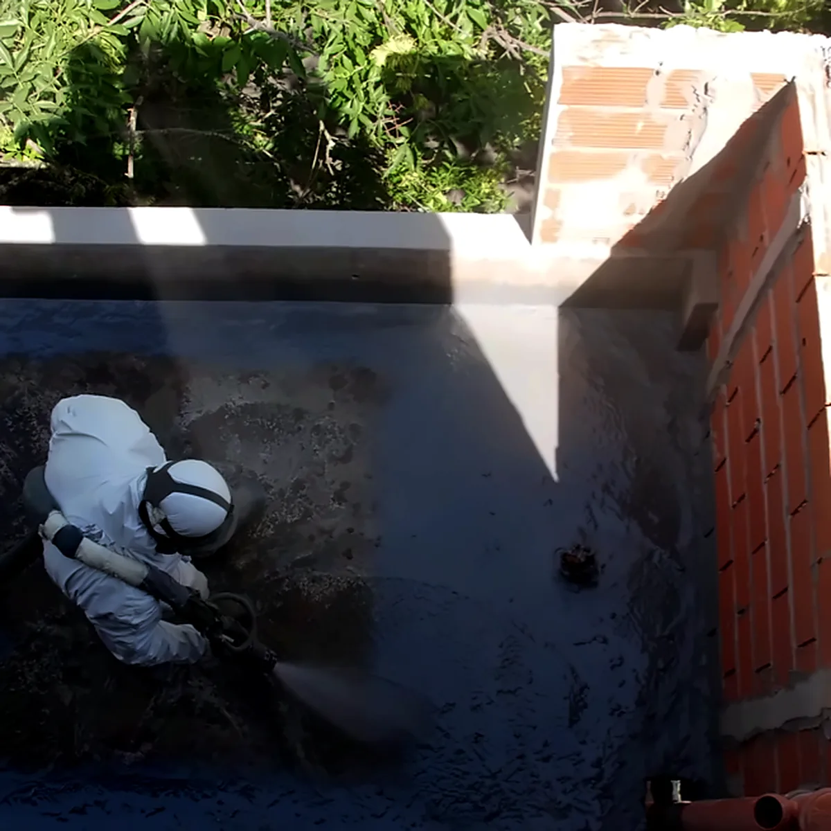 Applicator spraying polyurea on a balcony of a residential building in Buenos Aires, Argentina