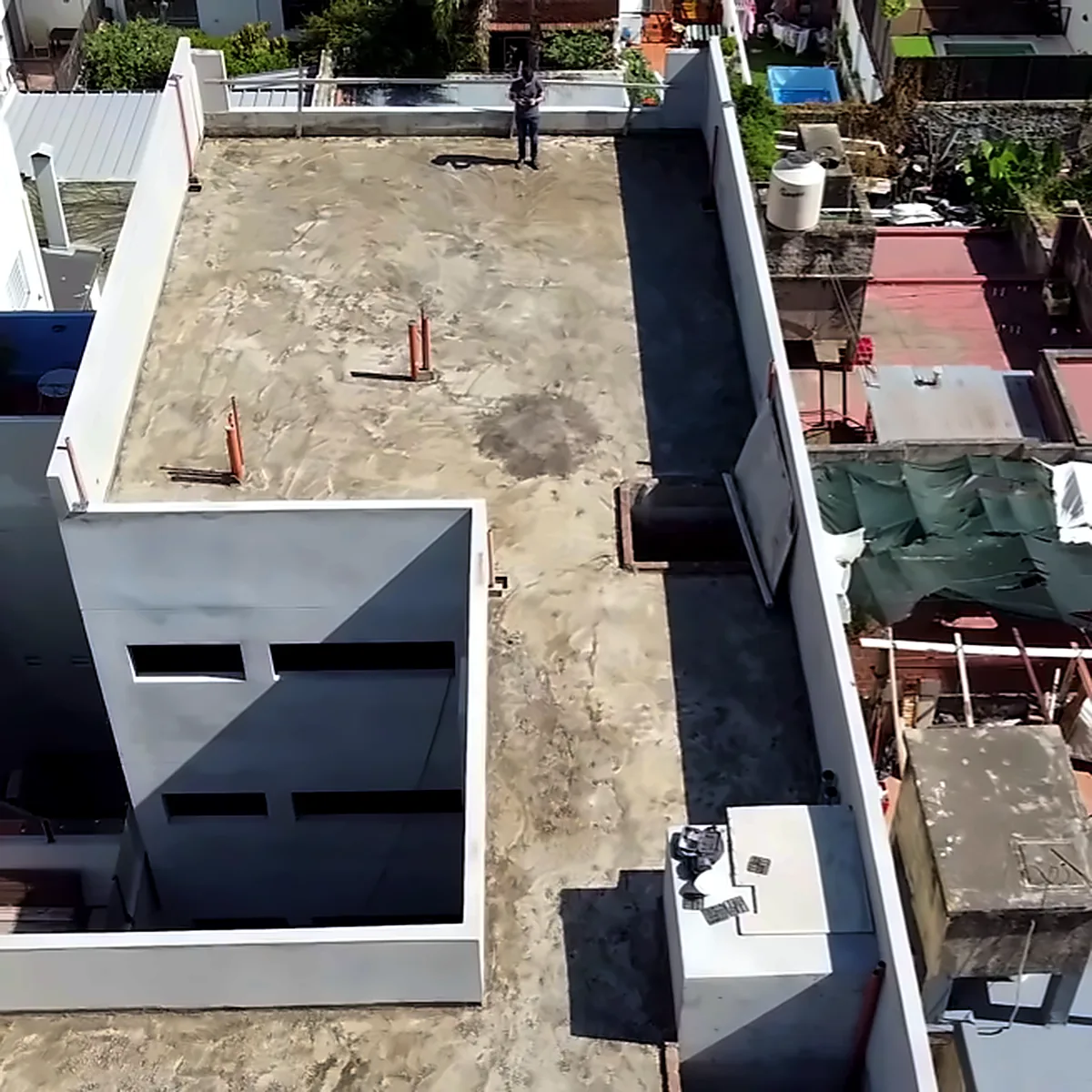 Aerial view of the bare concrete roof of a residential building in Buenos Aires before the membrane